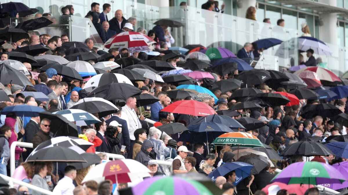 Racegoers holding up umbrellas due to the rain during Derby Day